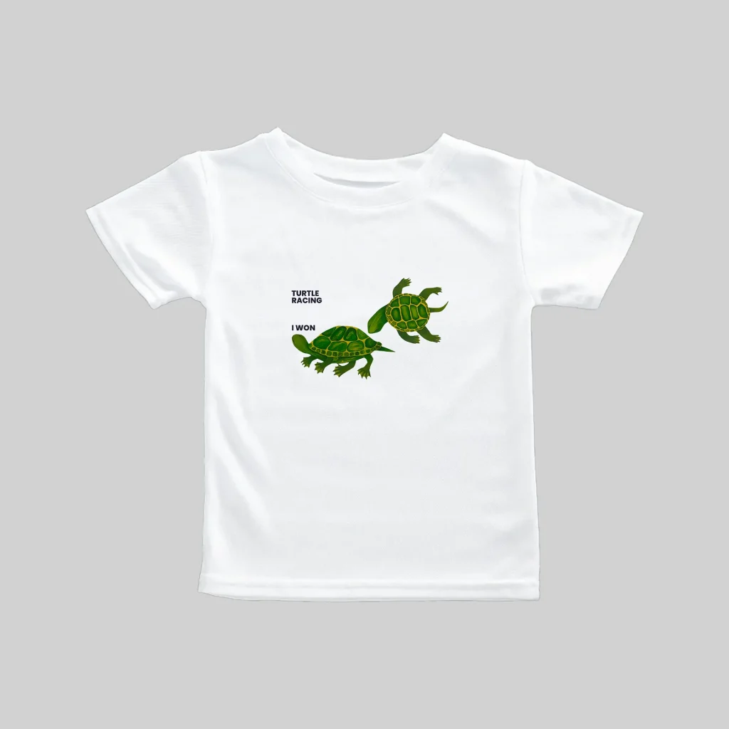 White t-shirt with a cute green dinosaur graphic and text.