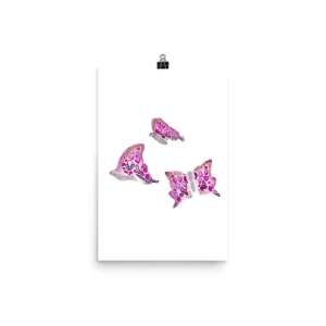 Three pink butterflies in various flight positions on a white background.