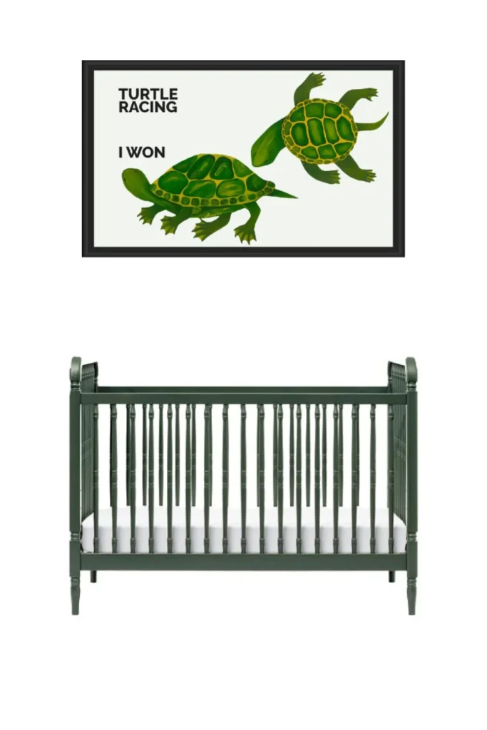 A green crib under a framed turtle race poster.