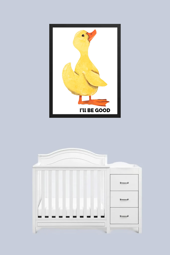 A white baby crib under a framed poster of Donald Duck saying "I'll be good."