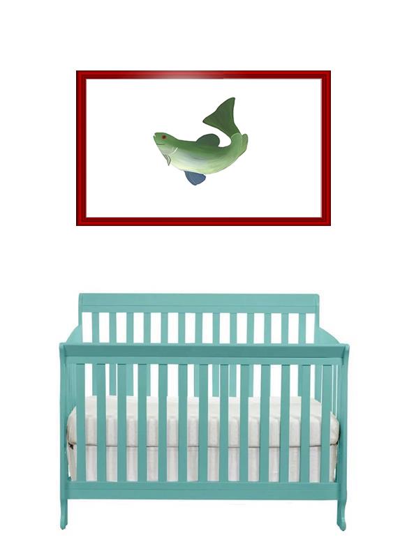 A baby crib beneath a framed fish artwork on a white wall.
